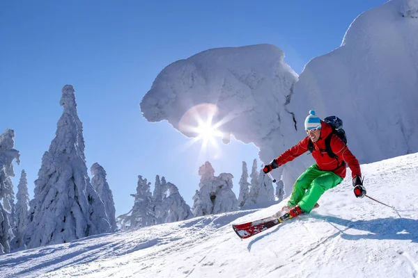 Skifahrer fährt im Hochgebirge vor blauem Himmel abwärts — Stockfoto