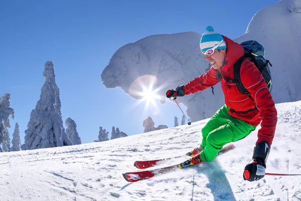 Σκιέρ σκι κατάβασης σε ψηλά βουνά κατά μπλε ουρανό — Φωτογραφία Αρχείου