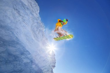 Mavi gökyüzüne atlayan snowboardcu