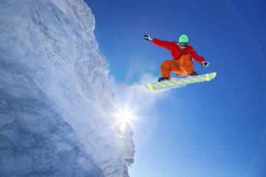 Mavi gökyüzüne atlayan snowboardcu