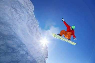 Mavi gökyüzüne atlayan snowboardcu