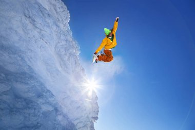 Mavi gökyüzüne atlayan snowboardcu