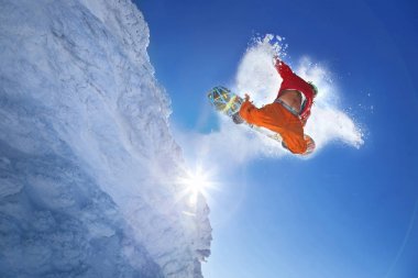 Mavi gökyüzüne atlayan snowboardcu