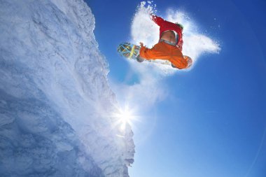 Mavi gökyüzüne atlayan snowboardcu