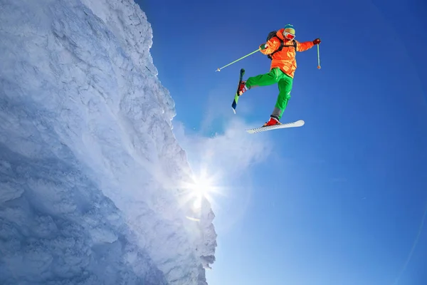 Skifahrer springt gegen blauen Himmel vom Felsen — Stockfoto