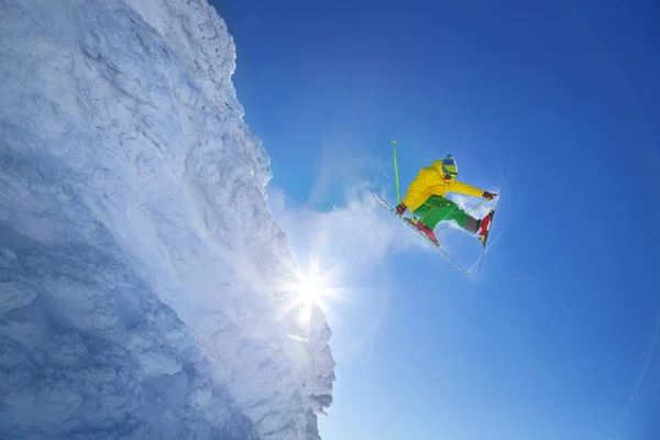 Skifahrer springt gegen blauen Himmel vom Felsen — Stockfoto