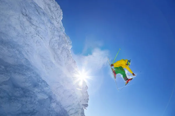 Skifahrer springt gegen blauen Himmel vom Felsen — Stockfoto