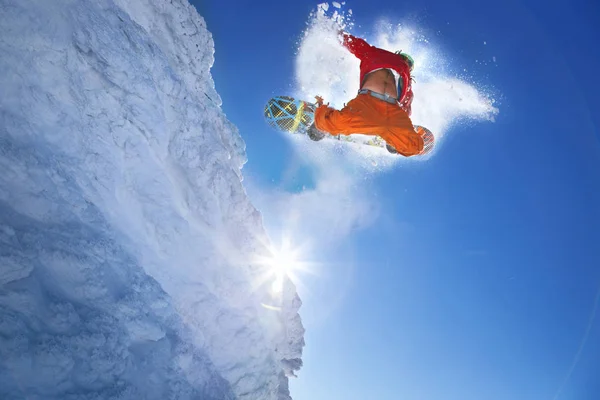 Snowboarder springt gegen blauen Himmel — Stockfoto