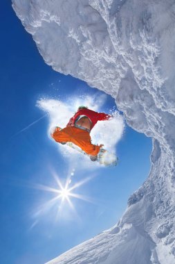 Mavi gökyüzüne atlayan snowboardcu