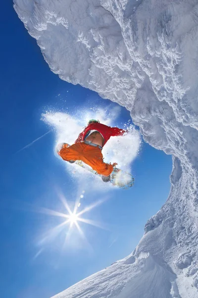 Mavi gökyüzüne atlayan snowboardcu