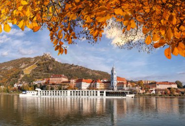 Duernstein Kalesi ve sonbahar süre içerisinde Avusturya Tuna nehrinde tekne ile köy