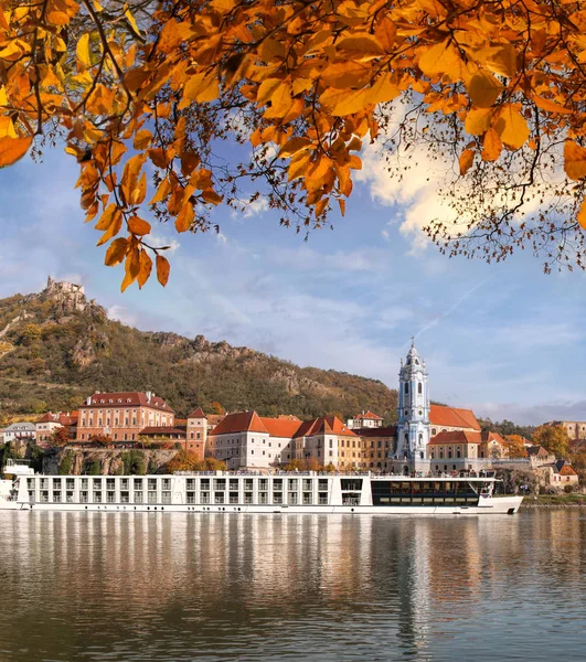 DUERNSTEIN CASTLE AND VILLAGE WITH BOAT ON DANUBE RIVER DURING AUTUMN TIME IN AUSTRIA — Stock Photo, Image