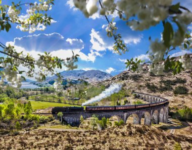 Glenfinnan demiryolu Viyadüğü üzerinde göl günbatımı karşı Jacobite buharlı tren ile İskoçya'da