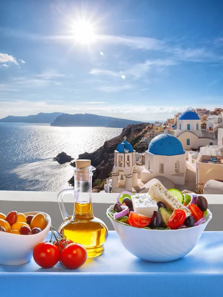 Griechischer salat gegen die berühmte kirche in oia dorf, santorini insel in griechenland — Stockfoto