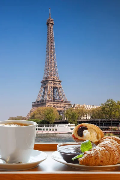 Koffie met croissants tegen beroemde Eiffeltoren in Parijs, Frankrijk — Stockfoto