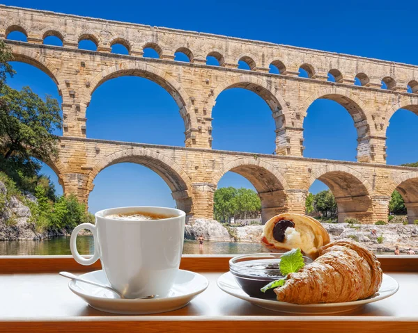 Coffee with croissants against Pont du Gard, is an old Roman aqueduct in Provence, France — Stock Photo, Image