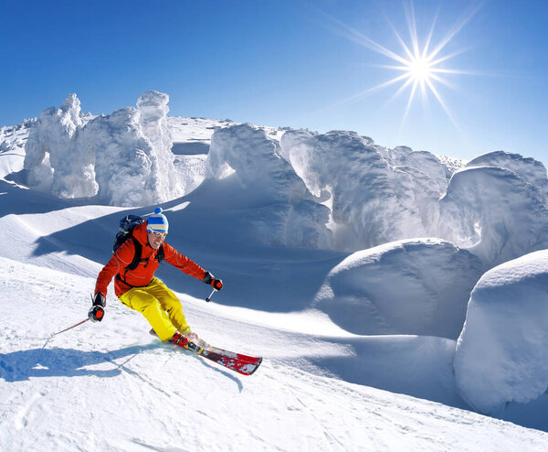 Горнолыжный спуск в высоких горах против голубого неба
