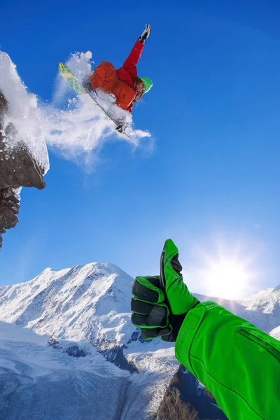 Сноубордист стрибає проти блакитного неба у високих горах — стокове фото