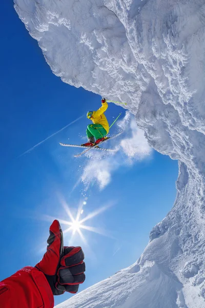 Skier стрибає проти блакитного неба зі скелі — стокове фото