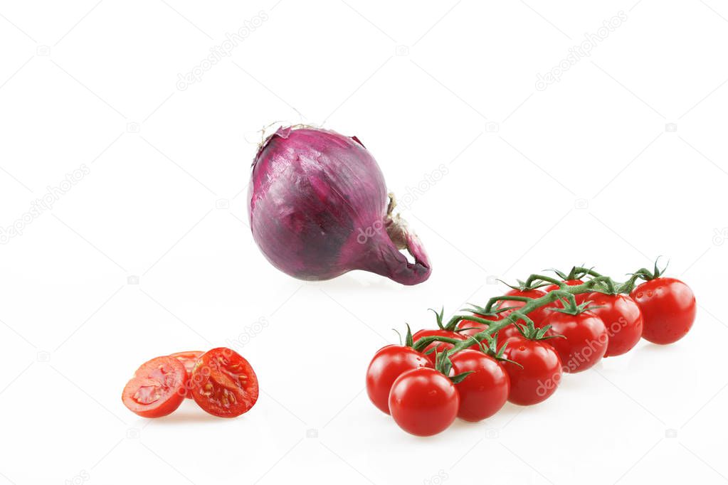 Red cherry tomatoes, halved tomatoes and an onion