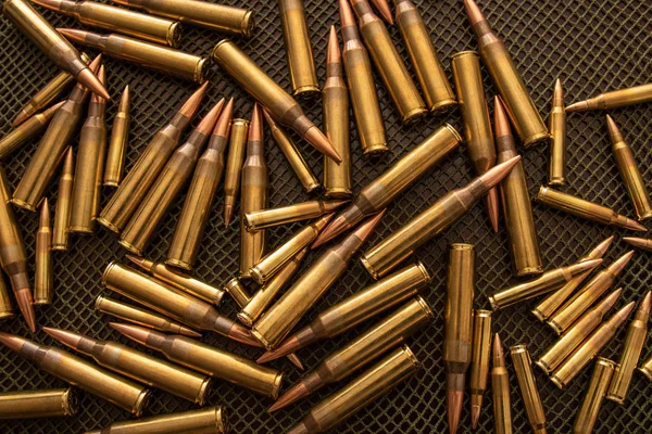 许多子弹（口径.338和.223）放在有绿色网的桌子上 图库图片