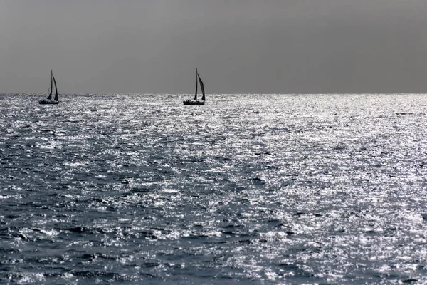 Две лодки, плывущие на горизонте вглубь океана - романтическая сцена — стоковое фото