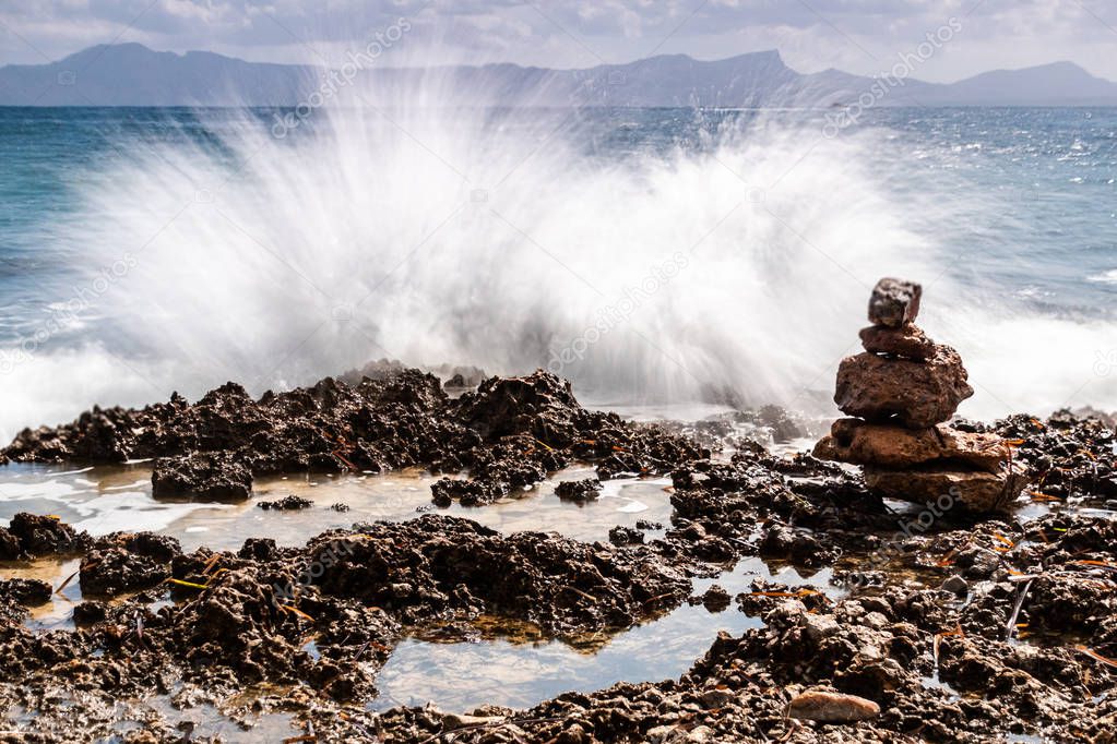 Waves crashing to some rocks at the coast shore - longexposure photography