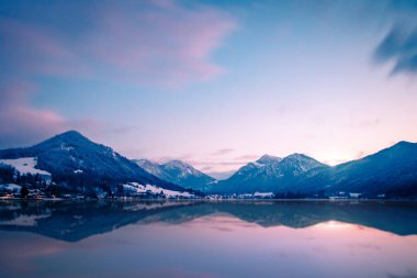 Almanya, Bavyera 'nın güneyindeki Schliersee Gölü' nün arka planında dağlar, mavi gökyüzü ve güzel yansımaları var.