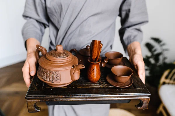 Чоловік тримає тацю з набором для китайської чайної церемонії. — стокове фото