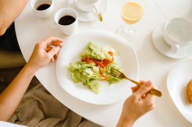 Kız domates ve sebze salatası yiyor.