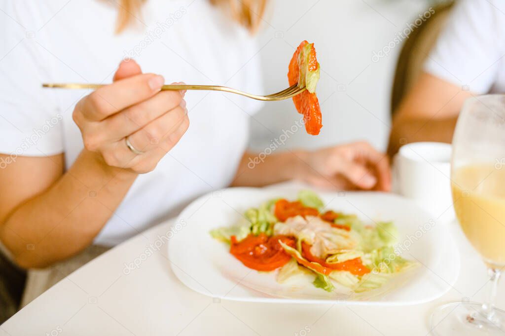 the girl eats a salad of tomatoes and vegetables