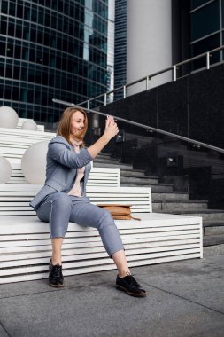  Takım elbiseli genç kız merdivenlerde selfie çekiyor.
