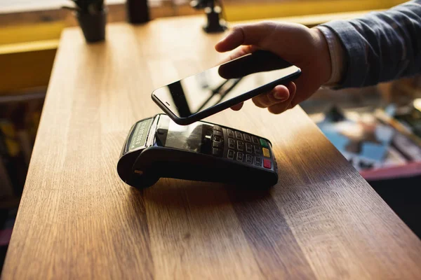 Contactless fizetés okostelefonjával. Fizet egy smartphone berendezés, a hitelkártya terminálon. Vezeték nélküli fizetés. — Stock Fotó