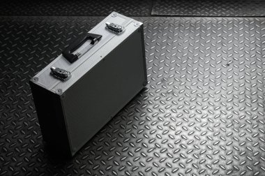 Metal arka planda kilitleri olan alüminyum demir bavul.