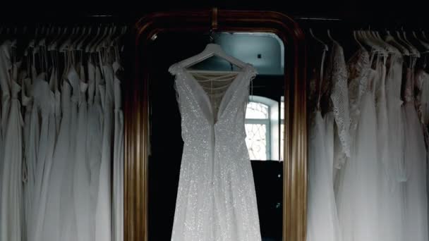 結婚式のサロンウェディングドレスはハンガーに掛けられます多くのドレス — ストック動画
