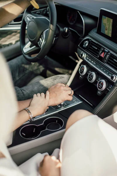 Mãos de amantes juntos em um carro de perto — Fotografia de Stock