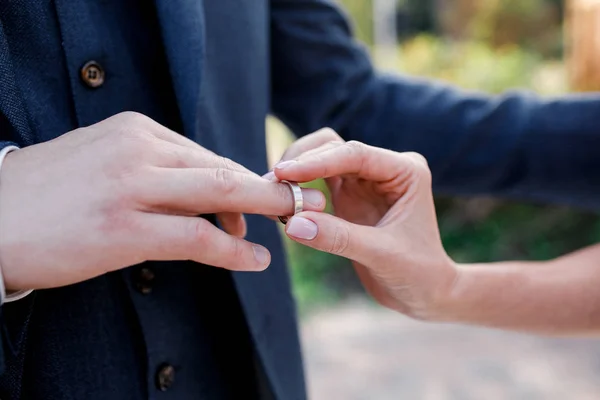 Tangan pernikahan dengan cincin. Birde memakai cincin di jari pengantin pria — Stok Foto