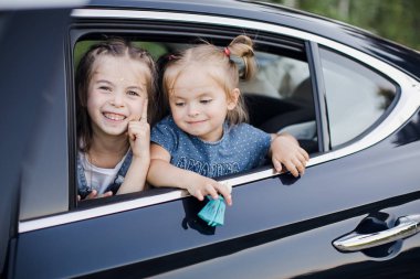 Arabanın camından bakan iki küçük kız. Mutlu çocuklar.. 