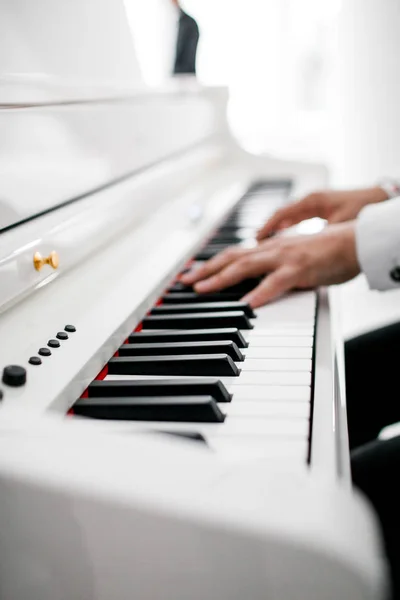 Un pianista con traje blanco toca el piano — Foto de Stock