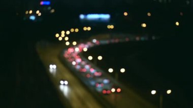 Gecenin karanlığında bulanık arkaplanda güzel, ışıltılı bir bokeh. Şehir caddesindeki trafik sıkışıklığında araba ışıklarından yuvarlak renkli bokeh parlıyor. Soyut kavram.