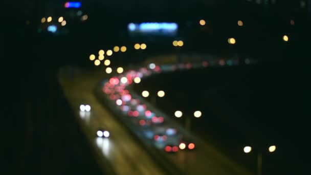 Prachtige glinsterende bokeh in donkere wazige achtergrond 's nachts. De ronde kleurrijke bokeh glans van auto lichten in de file op straat. Samenvatting. — Stockvideo