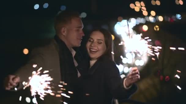 O par romântico no amor celebra em conjunto o início do ano novo ou a vida noturna da festa do evento com fogo sparkler — Vídeo de Stock
