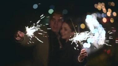 Birbirine aşık genç bir çift maytapları elinde tutuyor.