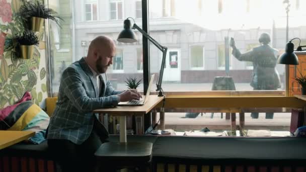 穿着西服的商人在咖啡店的笔记本电脑上打字 — 图库视频影像