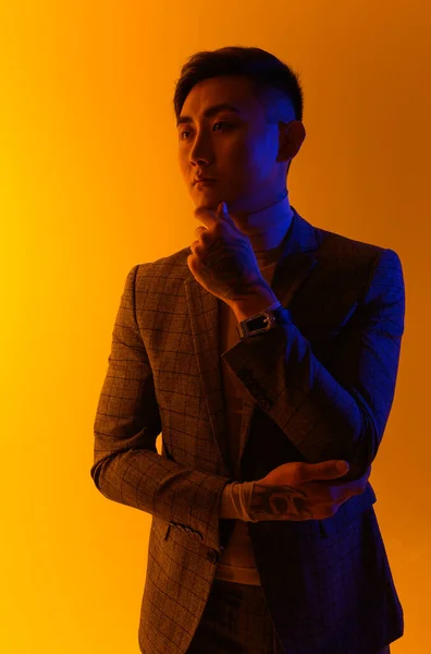Portrét mladého Asiata stojícího nad žlutým pozadím. Módní asijský muž — Stock fotografie