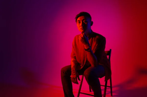 Módní korejský muž v ateliéru na barevném pozadí — Stock fotografie