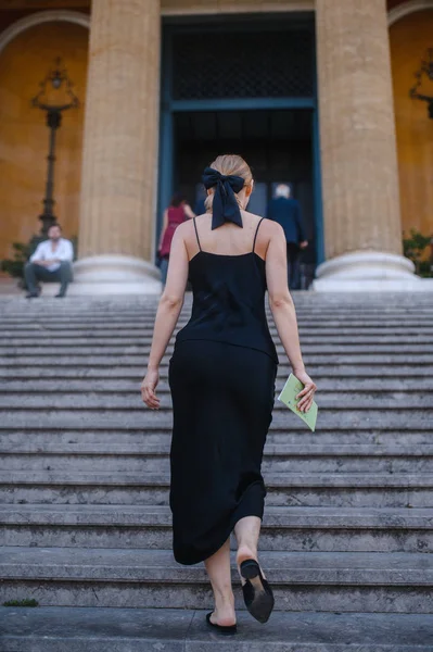 Young girl in black dress walks on European streets — Stock Photo, Image
