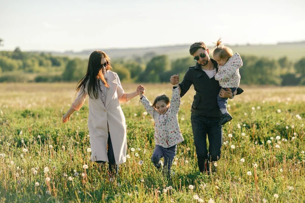 Щаслива молода сім'я проводить час разом за межами зеленої природи — стокове фото