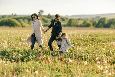 Mutlu aile babası, anne ve kız gün batımında doğada