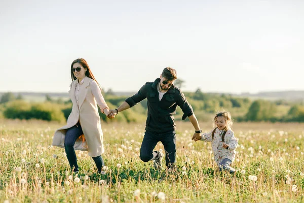 Щасливий батько сім'ї, мати і дочка на природі на заході сонця — стокове фото